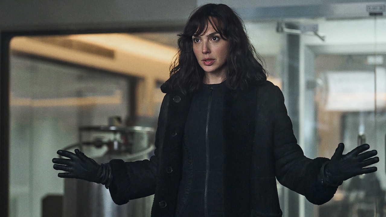 Gal Gadot in All or Nothing, wearing all black inside an office-like building